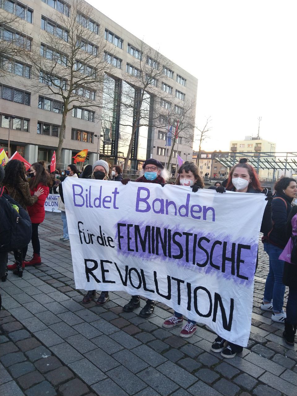 Die AG Feminismus hält ein Banner beim 8. März: Bildet Banden für die feministische Revolution
